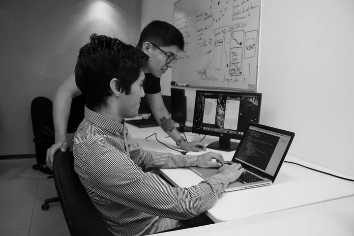 Dos personas de Kore trabajando frente a computadoras.