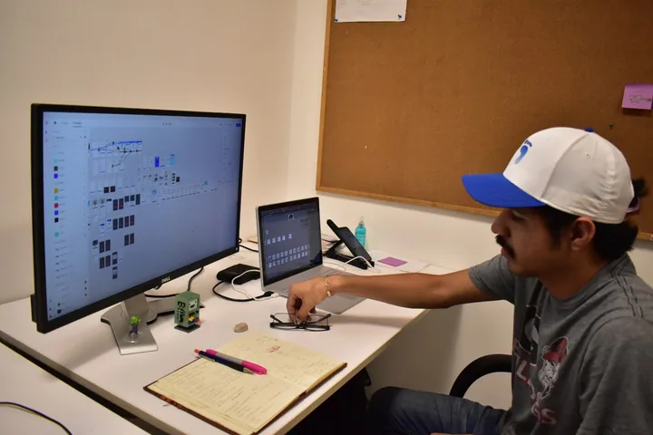Persona de Kore revisando pantallas de diseño en su espacio de trabajo.