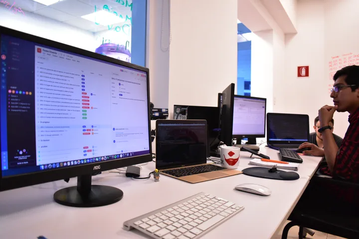 Espacio de trabajo de Kore con monitores y una persona trabajando.